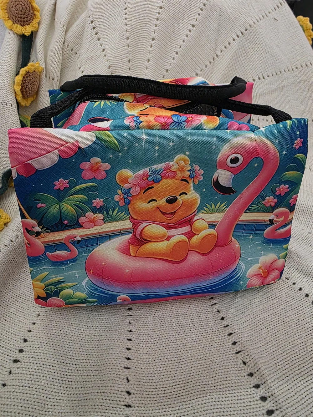 Insulated lunch bag features a playful design of Winnie the Pooh wearing a color